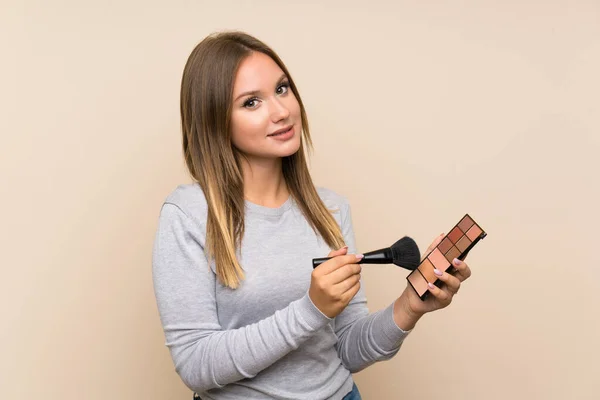 Teenager girl with makeup palette over isolated background — Stock Photo, Image