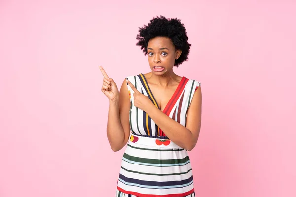 Африканська Американка Через Ізольований Рожевий Фон Перелякана Вказує Бік — стокове фото