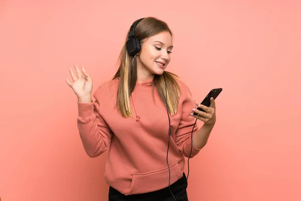 Ragazza Adolescente Che Ascolta Musica Con Cellulare Sfondo Rosa Isolato — Foto Stock