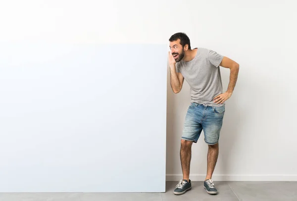 Jovem Homem Bonito Com Barba Segurando Grande Cartaz Azul Vazio — Fotografia de Stock