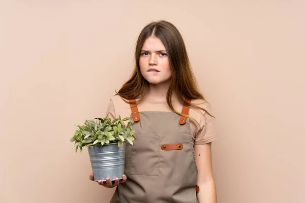Adolescente Ucraniana Jardinero Niña Sosteniendo Una Planta Que Tiene Dudas — Foto de Stock