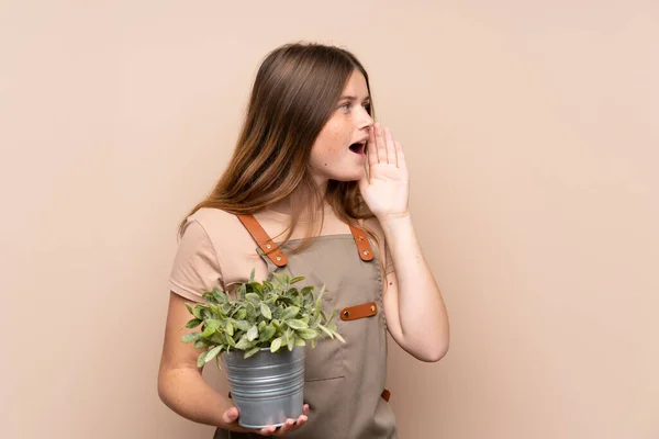 Adolescente Ucraniana Jardinero Chica Sosteniendo Una Planta Gritando Con Boca — Foto de Stock