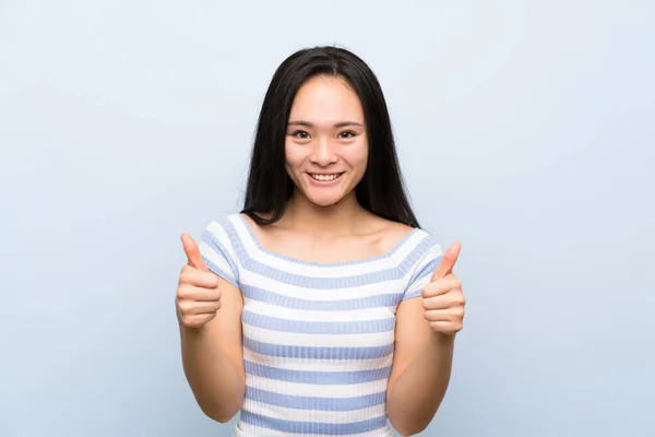 Tiener Aziatische Meisje Geïsoleerde Blauwe Achtergrond Geven Een Duim Omhoog — Stockfoto