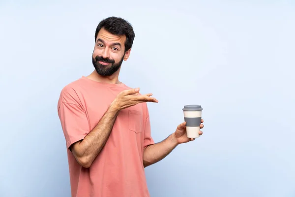 Jongeman Met Baard Houdt Een Take Away Koffie Geïsoleerde Blauwe — Stockfoto