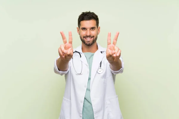 Joven Doctor Hombre Sobre Aislado Pared Verde Sonriendo Mostrando Signo — Foto de Stock