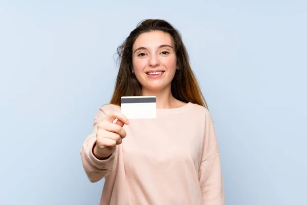 Joven Morena Sobre Fondo Azul Aislado Sosteniendo Una Tarjeta Crédito — Foto de Stock