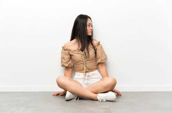 Tonåring Asiatisk Flicka Sitter Golvet Ser Sida — Stockfoto