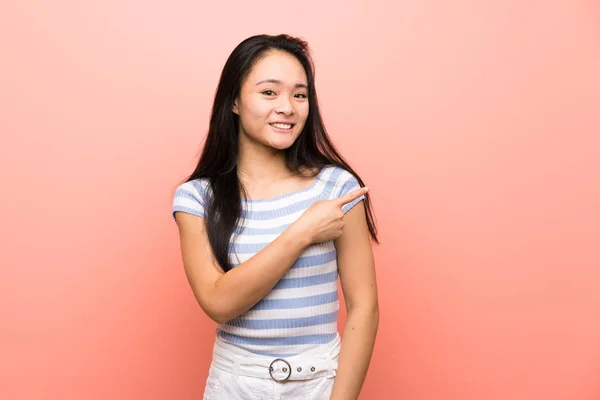 Tinédzser Ázsiai Lány Mint Elszigetelt Rózsaszín Háttér Mutatva Oldalra Hogy — Stock Fotó