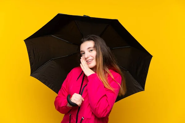 Joven Morena Sosteniendo Paraguas Sobre Aislado Fondo Amarillo Susurrando Algo — Foto de Stock