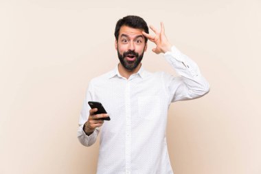 Cep telefonu tutan sakallı genç adam bir şeyin farkına vardı ve çözüme ulaşmaya çalışıyor.