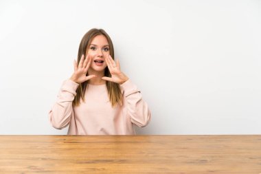 Ağzı tamamen açık bağıran bir masada genç kız