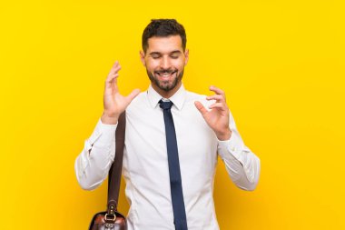 Izole sarı arka plan üzerinde Yakışıklı işadamı gülüyor