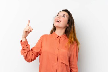 İzole edilmiş beyaz arka planda genç esmer kız yukarı bakıyor ve şaşırıyor.