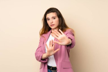 Ceketli genç esmer kız izole edilmiş arka planda gergin eller öne doğru uzanıyor.