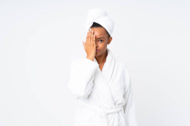 Siyah bornozlu Afro-Amerikalı bir kadın izole arka planda bir gözü elle kapatıyor.