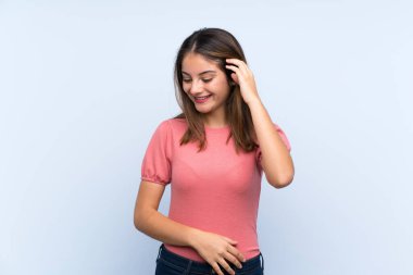 Genç esmer kız soyutlanmış mavi arka planda gülüyor.