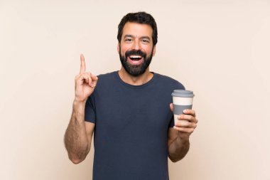 Elinde kahve tutan sakallı bir adam harika bir fikri işaret ediyor.