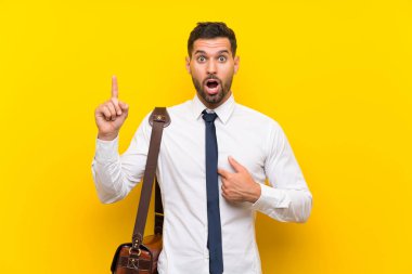 Sürpriz yüz ifadesi ile izole sarı arka plan üzerinde Yakışıklı işadamı