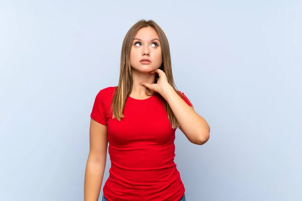 Adolescente Chica Sobre Aislado Azul Fondo Pensando Una Idea — Foto de Stock