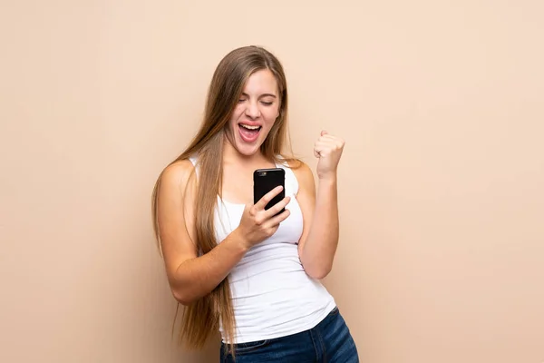 Adolescente Rubia Chica Sobre Aislado Fondo Con Teléfono Posición Victoria — Foto de Stock