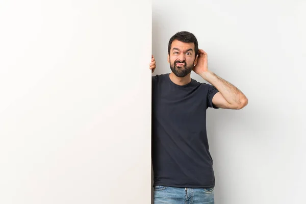 Young Handsome Man Beard Holding Big Empty Placard Having Doubts — Stock Photo, Image