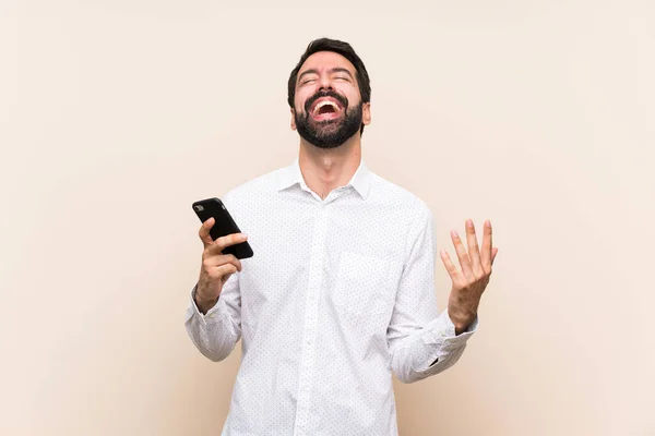 Elinde Cep Telefonu Olan Sakallı Genç Adam Çok Gülümsüyor — Stok fotoğraf