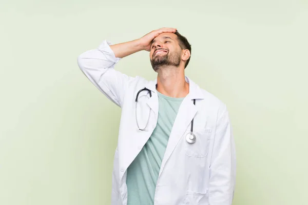Młody Lekarz Człowiek Przez Izolowany Zielony Ściana Śmiech — Zdjęcie stockowe