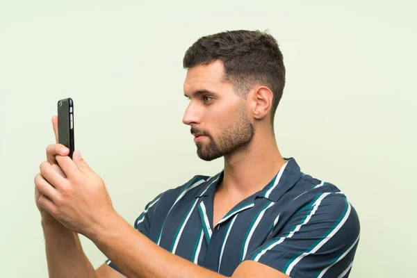 Junger schöner Mann mit einem Handy — Stockfoto