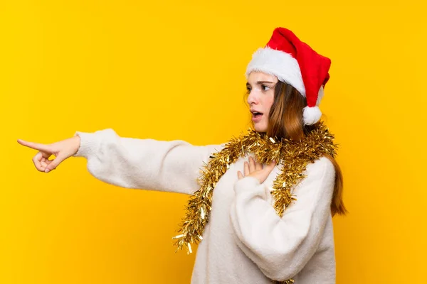 Menina Com Chapéu Natal Sobre Fundo Amarelo Isolado Apontando Dedo — Fotografia de Stock