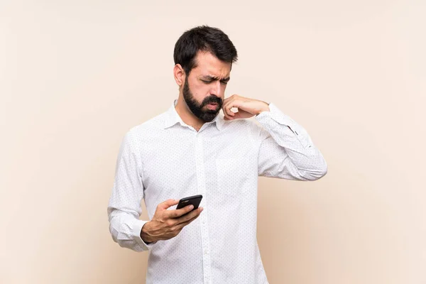 Junger Mann Mit Bart Hält Ein Handy Mit Müdem Und — Stockfoto