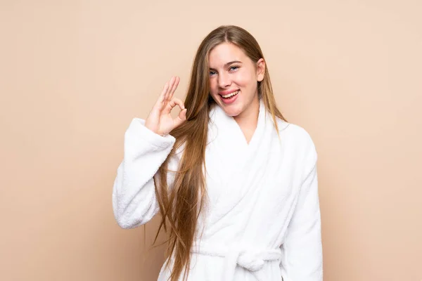 Teenager Mädchen Einem Bademantel Über Isoliertem Hintergrund Zeigt Ein Zeichen — Stockfoto