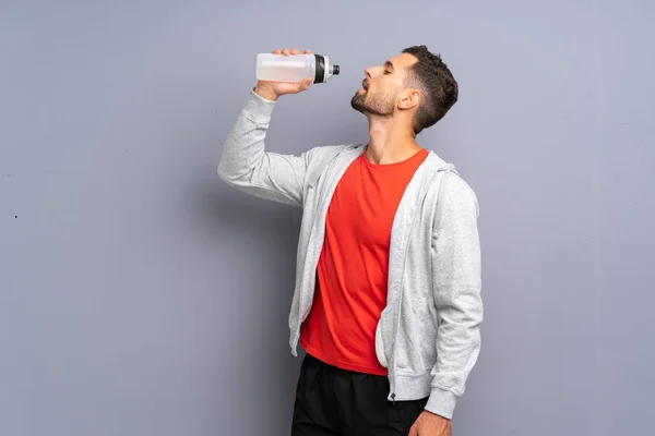 Νεαρός αθλητικός άνθρωπος με ένα μπουκάλι νερό — Φωτογραφία Αρχείου