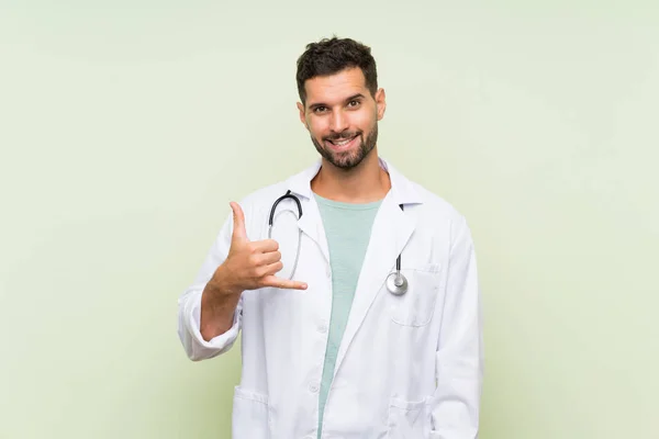 Joven Doctor Hombre Sobre Aislado Pared Verde Haciendo Gesto Teléfono —  Fotos de Stock