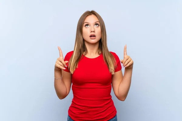 Teenager Mädchen Über Isoliertem Blauem Hintergrund Zeigt Mit Dem Zeigefinger — Stockfoto