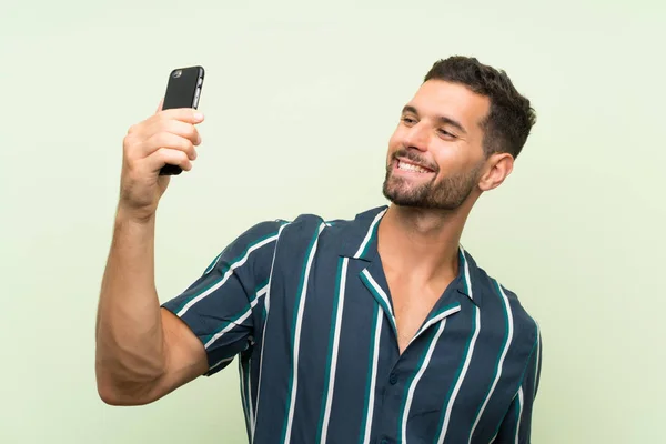 Junger schöner Mann mit einem Handy — Stockfoto