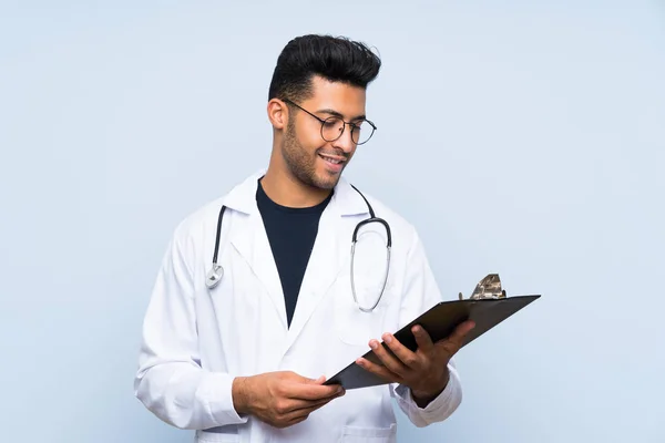 Jovem médico homem sobre isolado parede azul — Fotografia de Stock