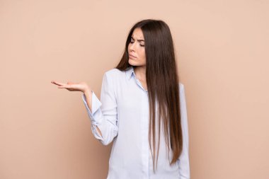 Şüphelerle copyspace tutan izole arka plan üzerinde genç kadın