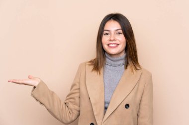 Arka planda izole edilmiş genç bir kadın. Kopyalama alanını avucunun içinde tutuyor.