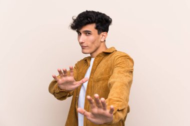 Arjantinli genç bir adam izole edilmiş arka planda sinirleri gergin ve ellerini öne uzatıyor.