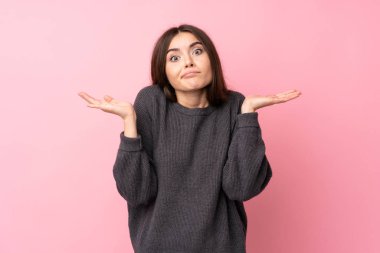 Soyutlanmış pembe arka planı olan genç bir kadın şüpheli hareketler yapıyor.