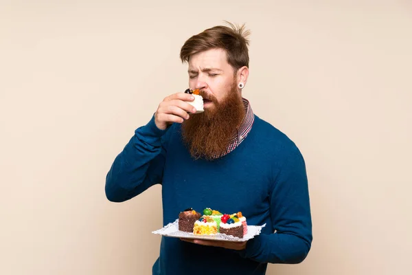 Roodharige Man Met Lange Baard Geïsoleerde Achtergrond Met Mini Cakes — Stockfoto