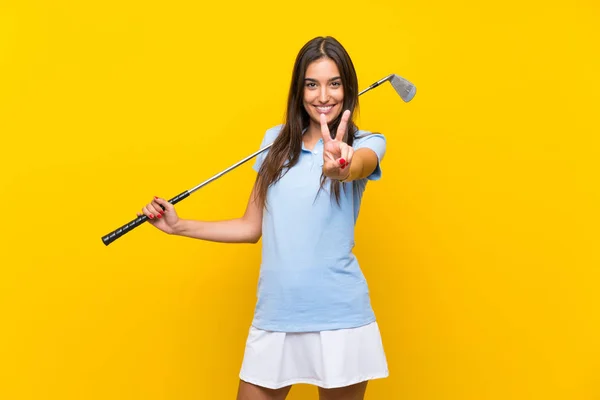 Young Golfer Woman Isolated Yellow Wall Smiling Showing Victory Sign — Stock Photo, Image