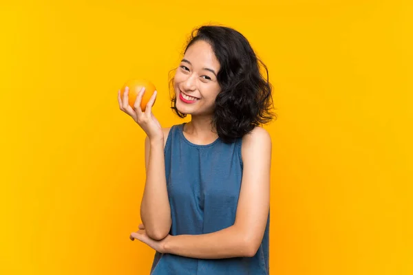 Asiatique jeune femme tenant une orange — Photo