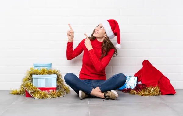 Chica Vacaciones Navidad Sentado Suelo Señalando Con Dedo Índice Una —  Fotos de Stock