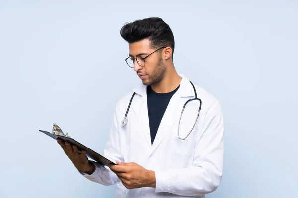 Jovem médico homem sobre isolado parede azul — Fotografia de Stock