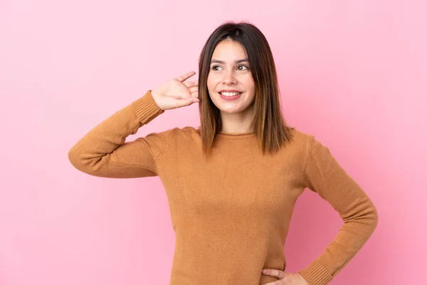 Jovem Mulher Sobre Fundo Rosa Isolado Ouvir Algo Colocando Mão — Fotografia de Stock