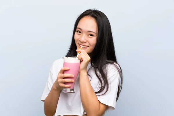 Подростковая азиатка с клубничным молочным коктейлем — стоковое фото