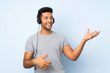 Kulaklık ve dans ile cep telefonu kullanarak izole arka plan üzerinde Genç yakışıklı adam