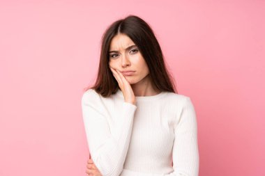 Izole pembe arka plan üzerinde genç kadın mutsuz ve sinirli