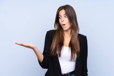 İzole edilmiş mavi arkaplan üzerinde Brezilyalı genç bir iş kadını.